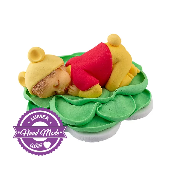 Alvó Winnie baba egy zöld virágon cukormasszából - Lumea